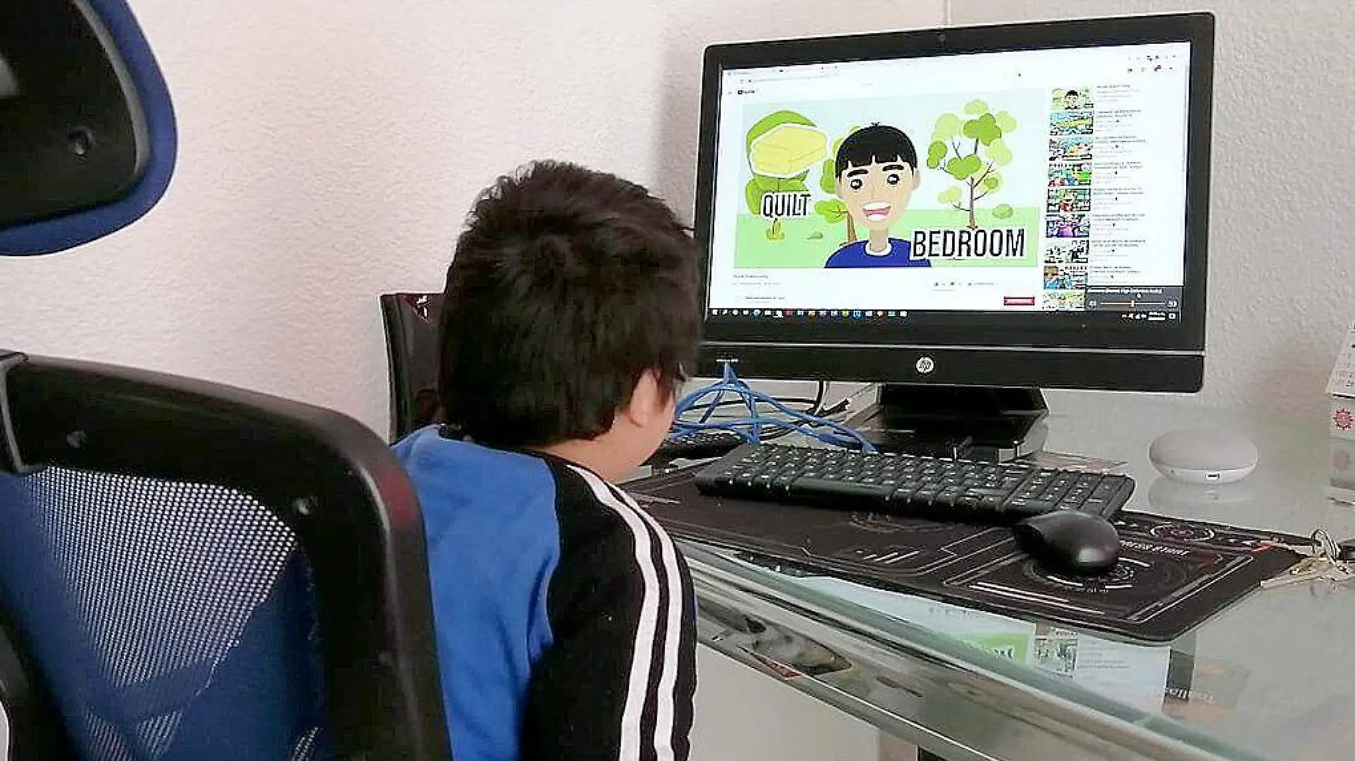 Niño aprendiendo inglés frente a la computadora